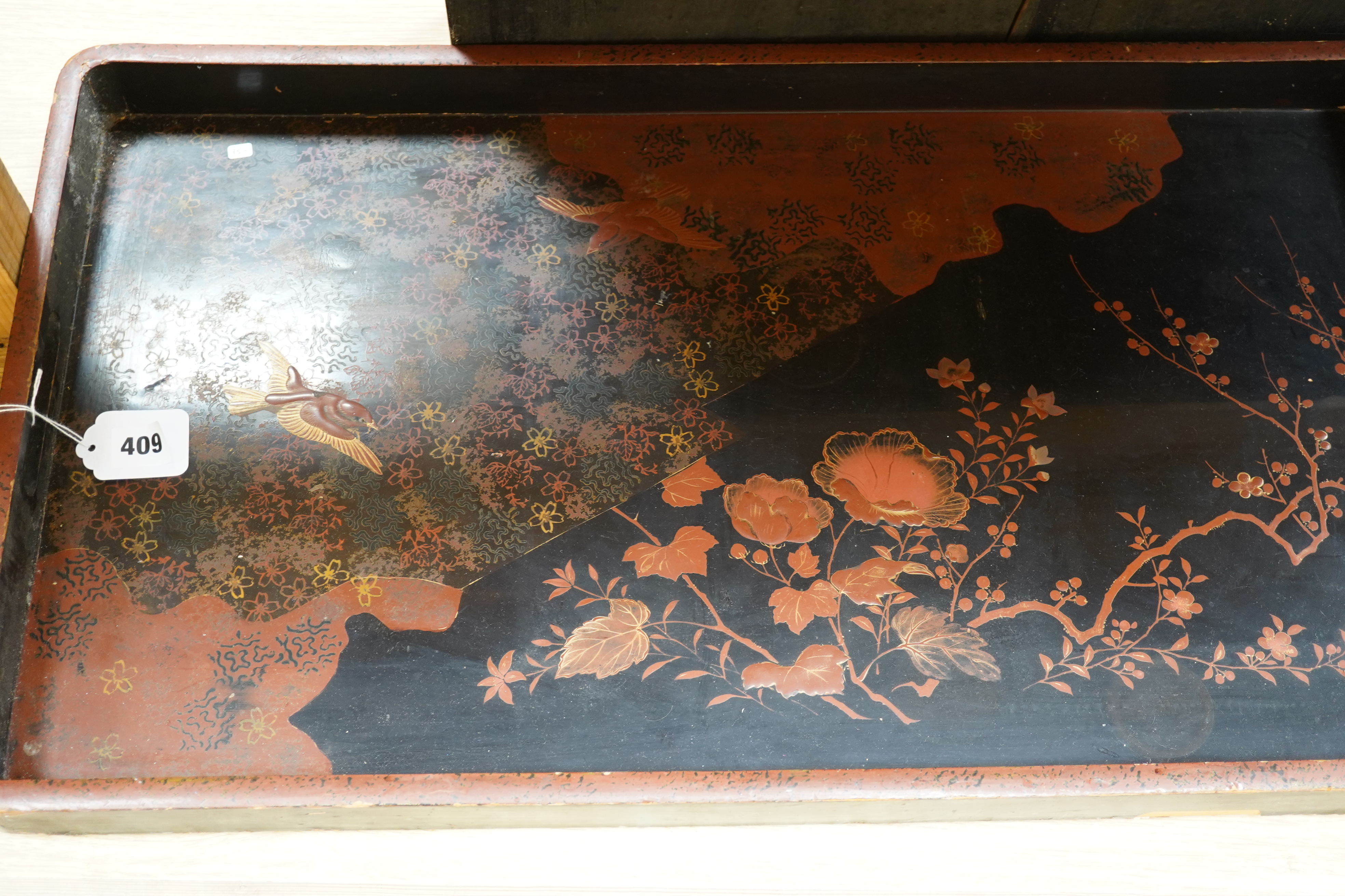 Three trays to include a butterfly wing example and a Japanese lacquered example decorated with birds and flowers, 75cm wide. Condition - poor to fair